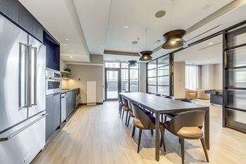 A modern kitchen with a long table and chairs.